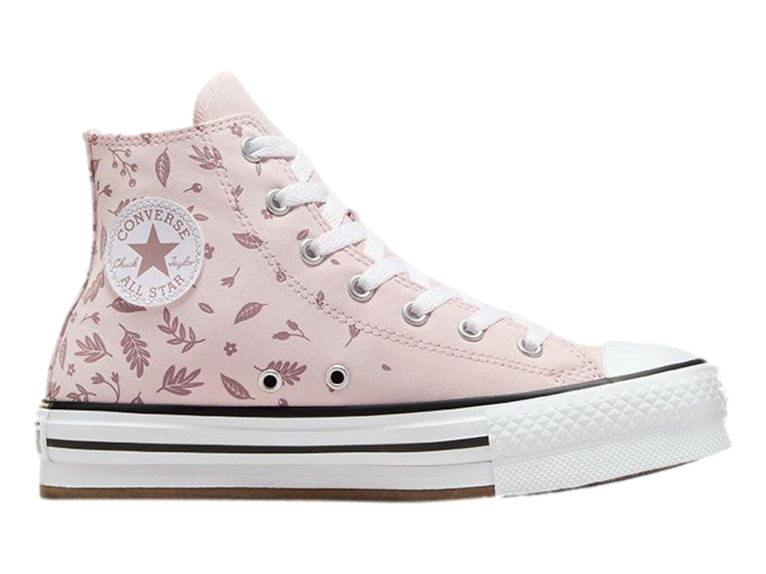 Tenis Converse rosa con estampado de hojas y suela de plataforma blanca.