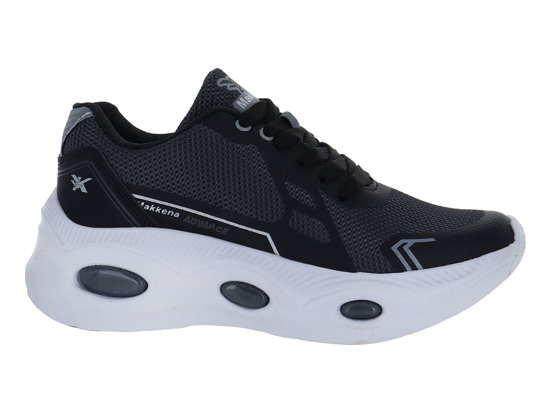 Zapato deportivo infantil color negro con suela blanca y detalles en gris.