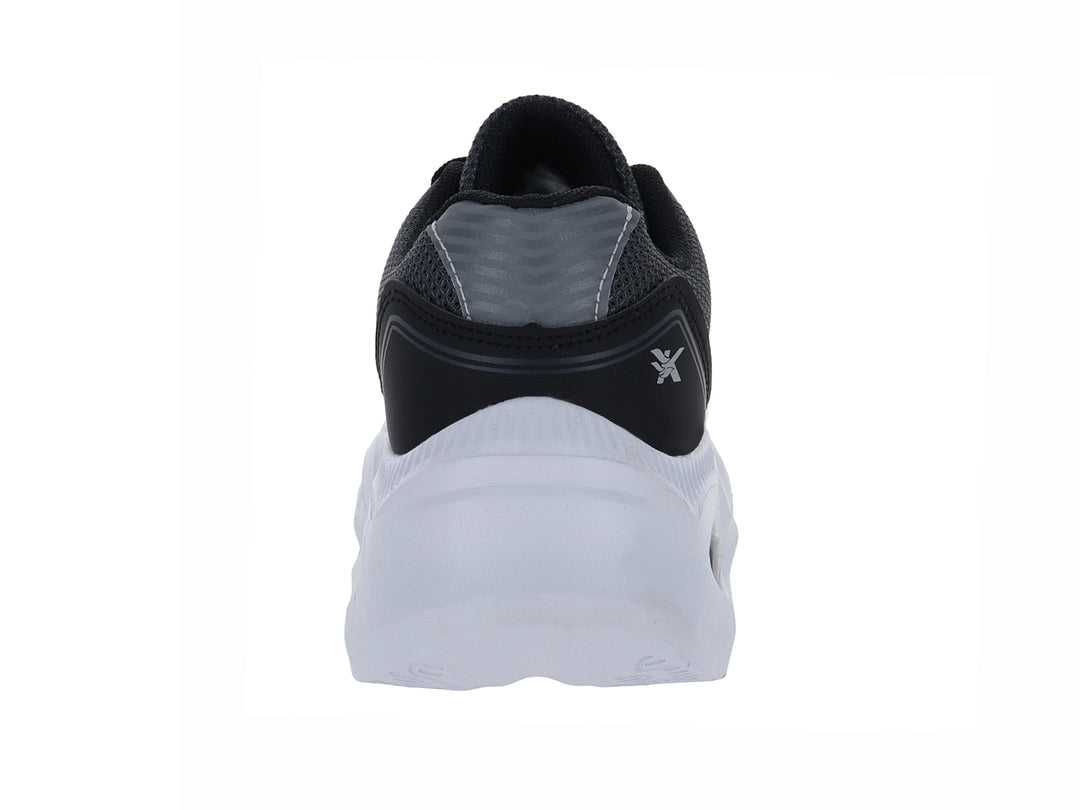 Zapato deportivo infantil color negro con suela blanca y detalles en gris.