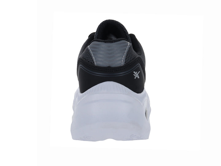 Zapato deportivo infantil color negro con suela blanca y detalles en gris.