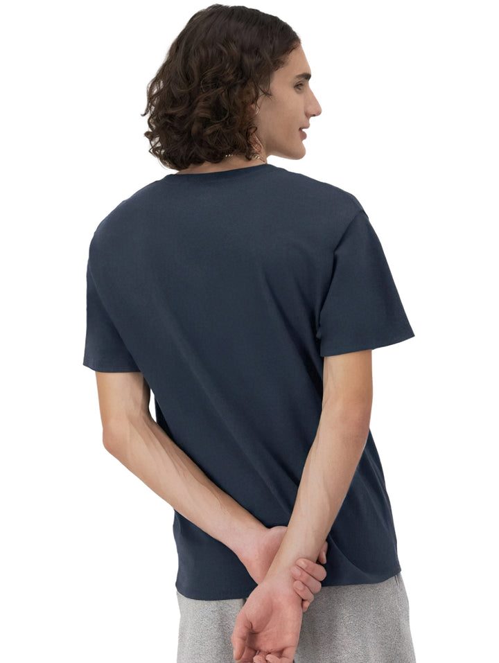 Hombre vistiendo una camiseta de manga corta color azul marino de la marca Champion con logotipo en el pecho.