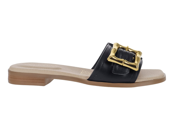 Sandalia plana color negro con hebilla dorada decorativa y suela color beige.