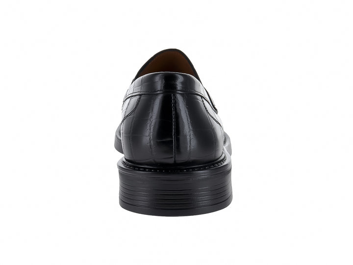 Zapato mocasín negro con textura de piel de lagarto y hebilla metálica plateada.