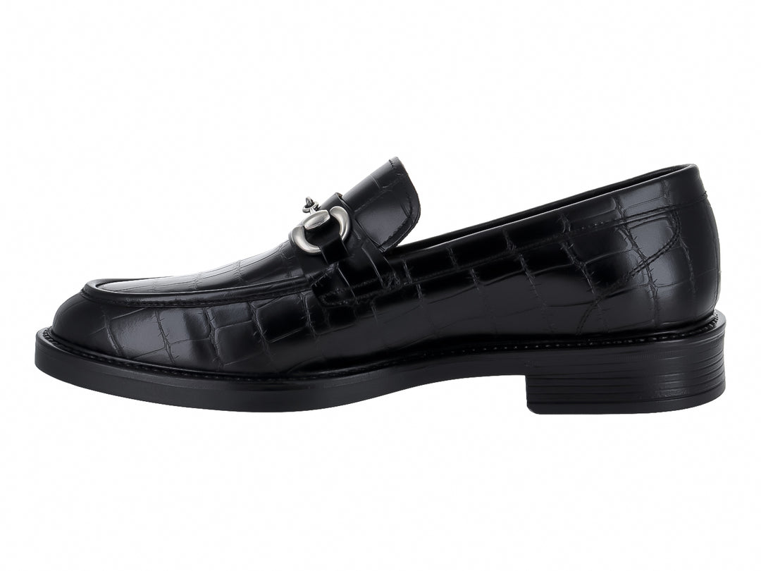 Zapato mocasín negro con textura de piel de lagarto y hebilla metálica plateada.