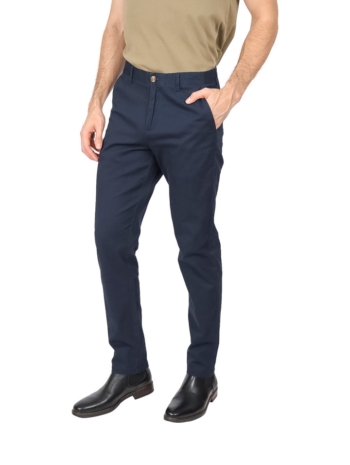 Hombre vistiendo un pantalón chino color marino de corte moderno.