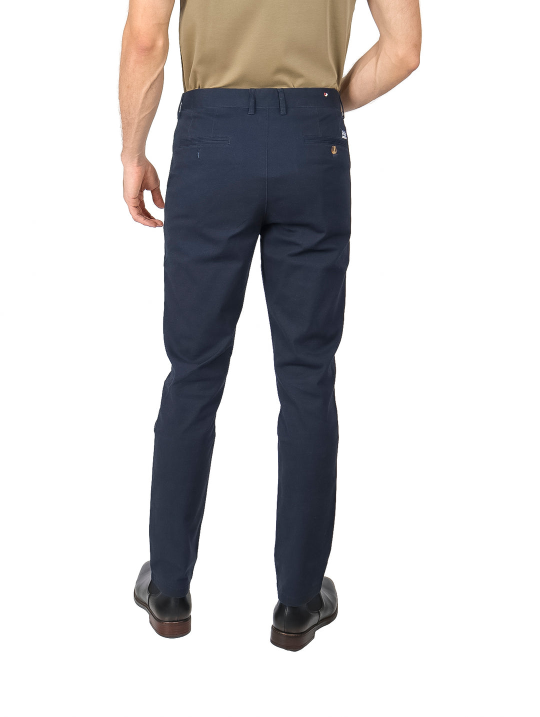 Hombre vistiendo un pantalón chino color marino de corte moderno.