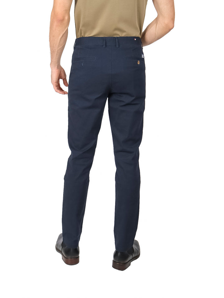 Hombre vistiendo un pantalón chino color marino de corte moderno.