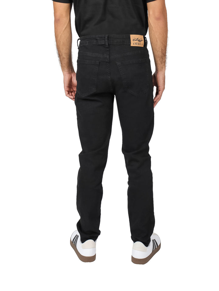Hombre vistiendo pantalones jeans Perry Ellis color negro en corte slim fit.
