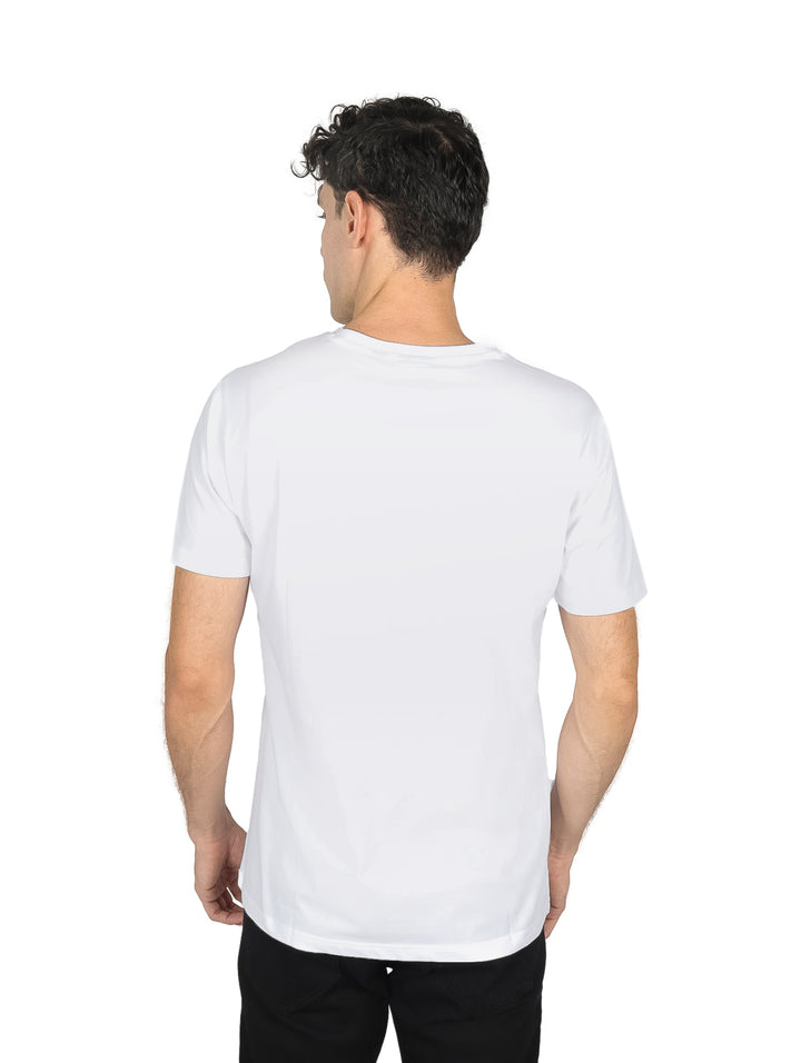 Hombre vistiendo una playera blanca de manga corta con texto estampado en el pecho.