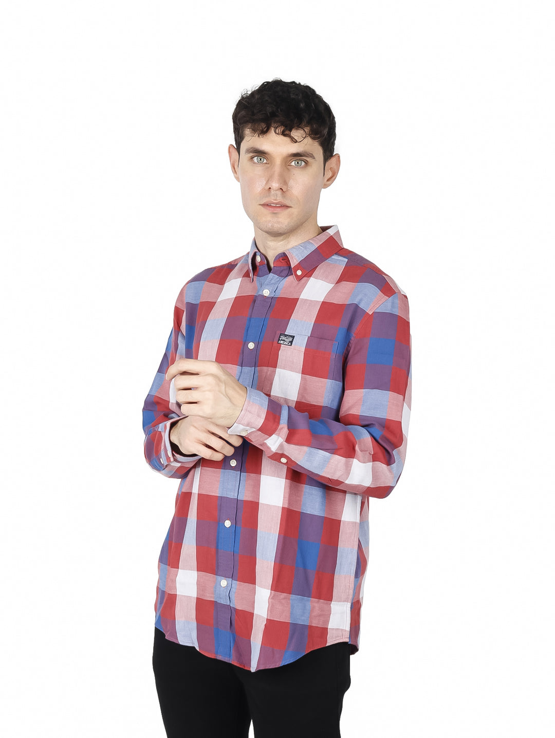 Hombre vistiendo una camisa de manga larga con estampado de cuadros en colores rojo, azul y blanco.