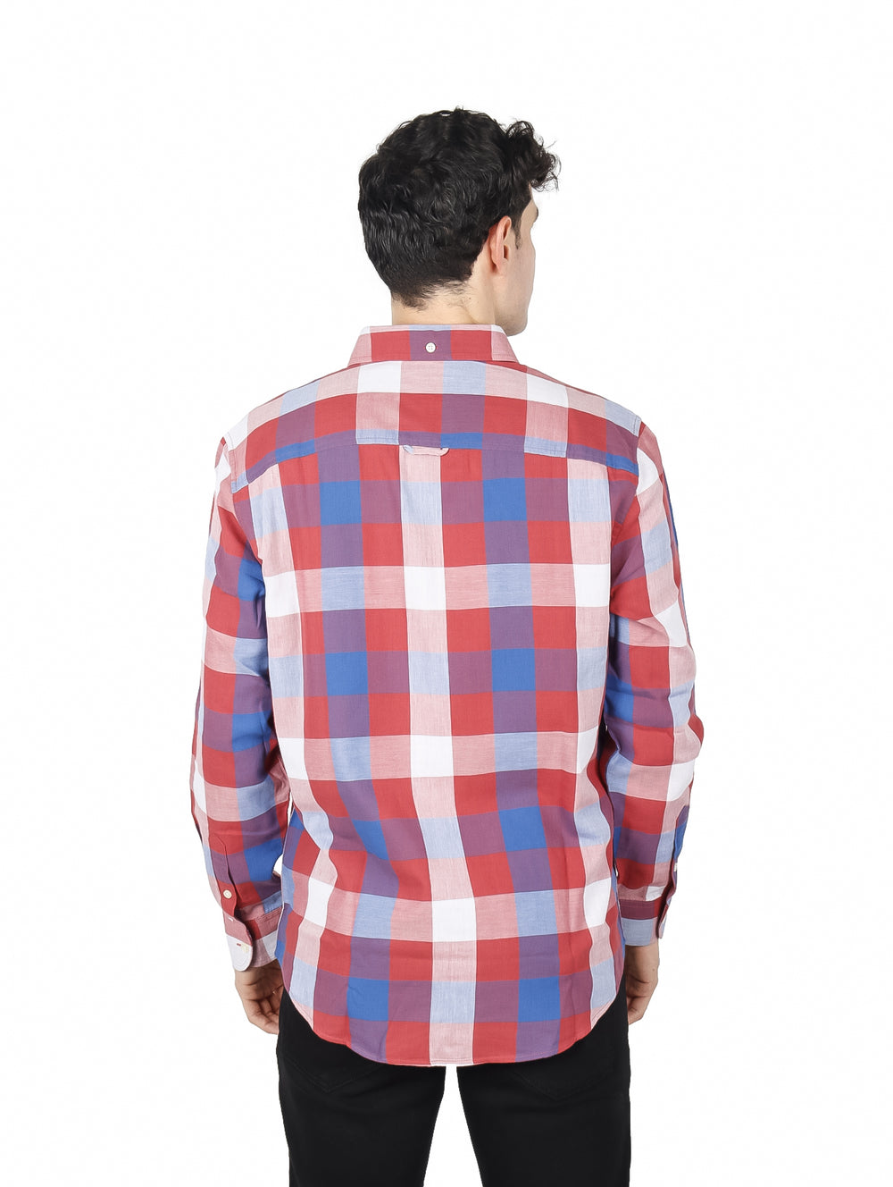 Hombre vistiendo una camisa de manga larga con estampado de cuadros en colores rojo, azul y blanco.