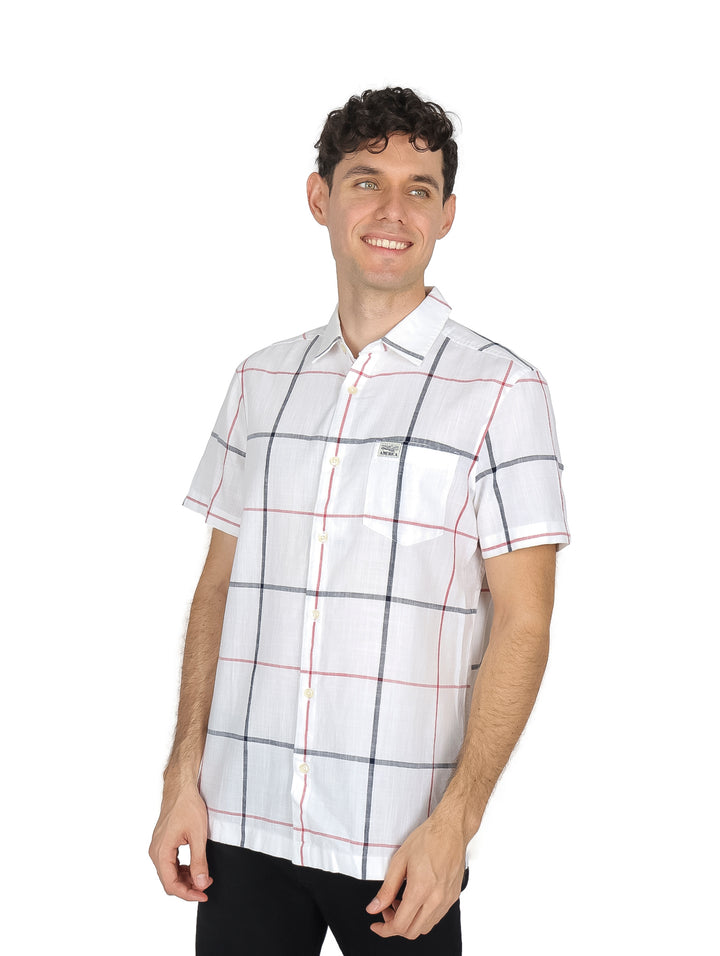 Hombre vistiendo una camisa blanca de manga corta con estampado de cuadros negros y rojos.