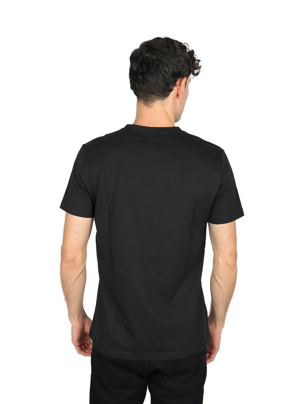 Hombre vistiendo una playera de manga corta color negro de la marca Perry Ellis.