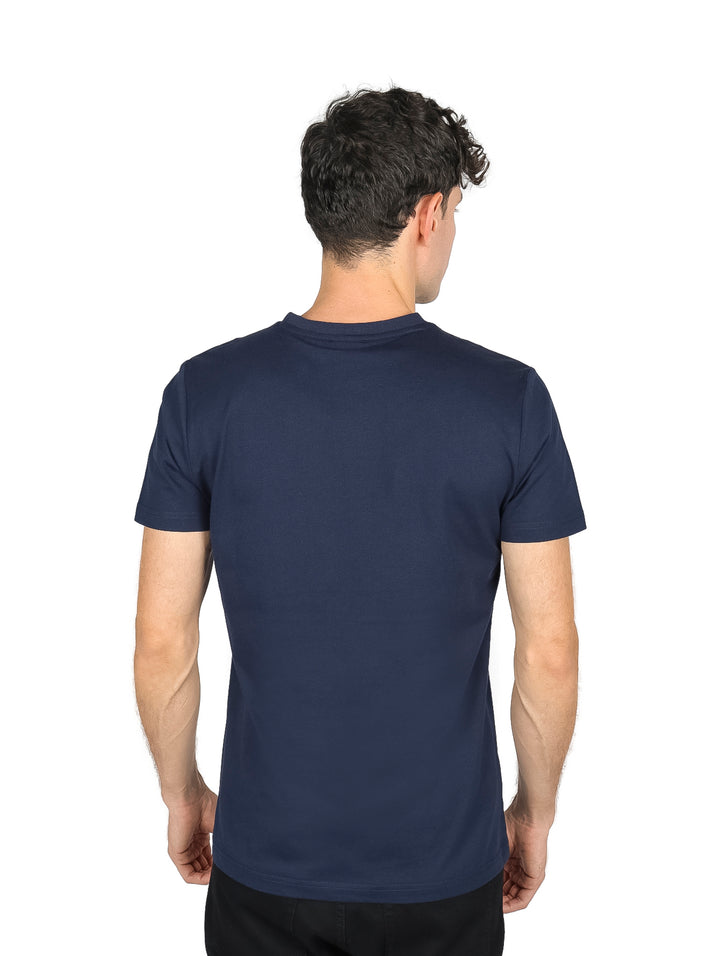 Hombre vistiendo una playera de manga corta color azul marino oscuro con un pequeño detalle blanco en el pecho.
