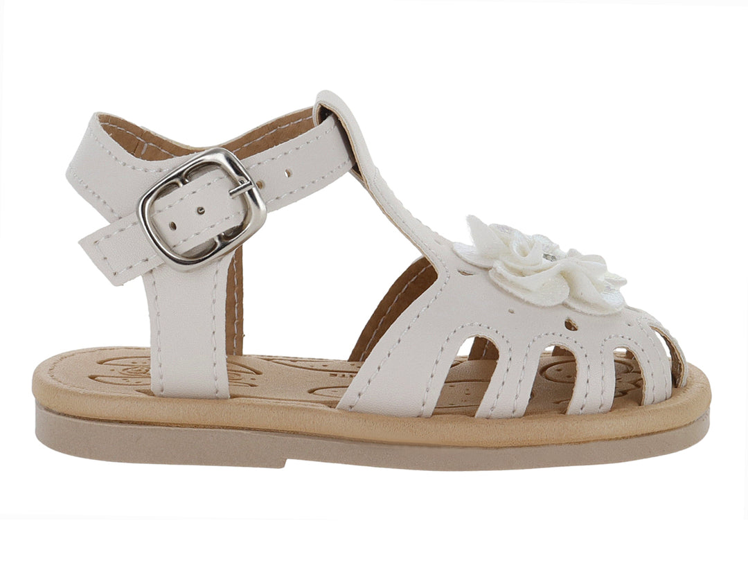 Sandalia blanca para niña con adorno de flor y hebilla metálica sobre suela beige.