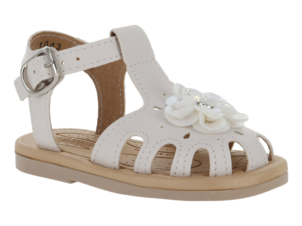 Sandalia blanca para niña con adorno de flor y hebilla metálica sobre suela beige.