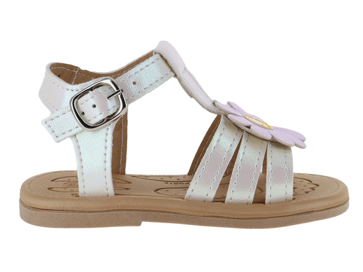 Sandalia blanca iridiscente para niña con adorno de flor rosa y suela beige.