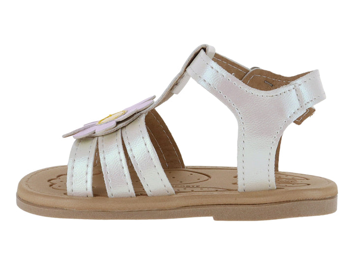 Sandalia blanca iridiscente para niña con adorno de flor rosa y suela beige.