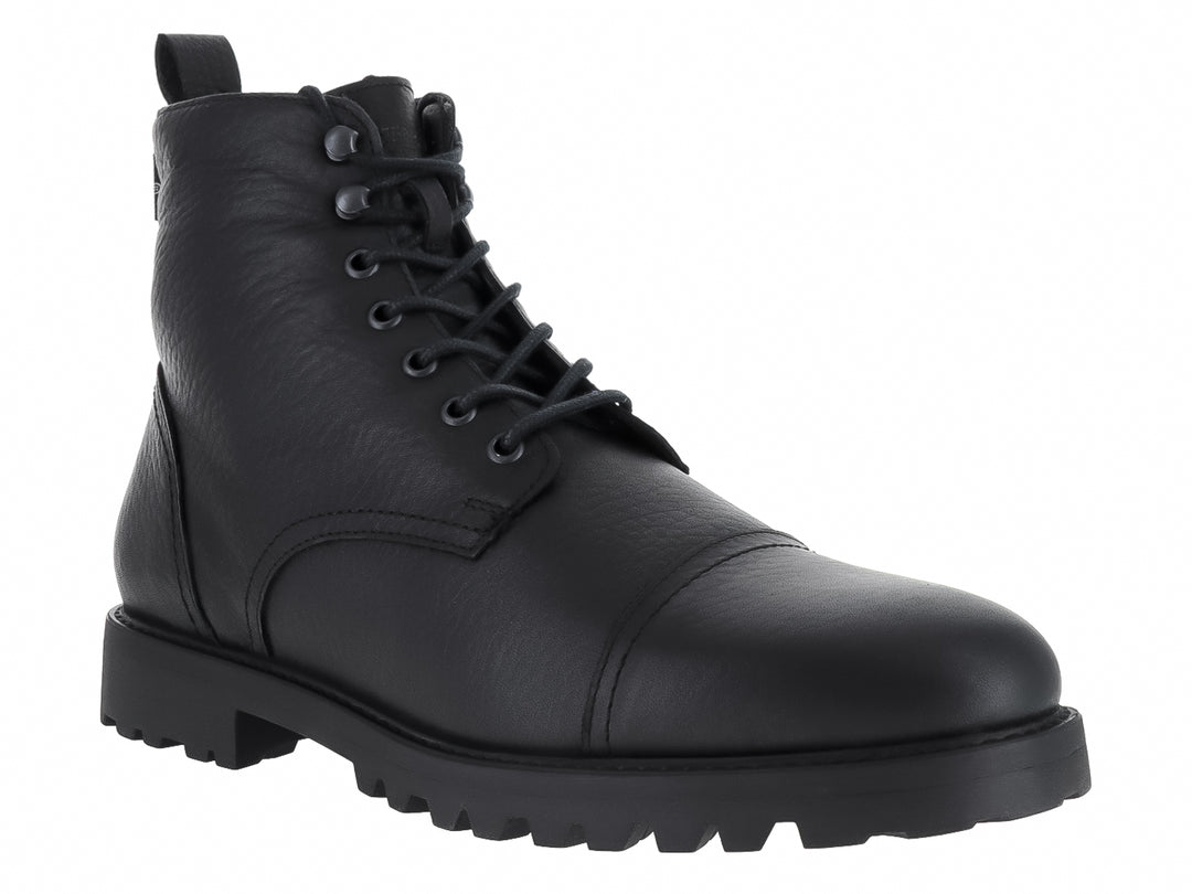 Bota negra de material sintético con agujetas y suela gruesa dentada.