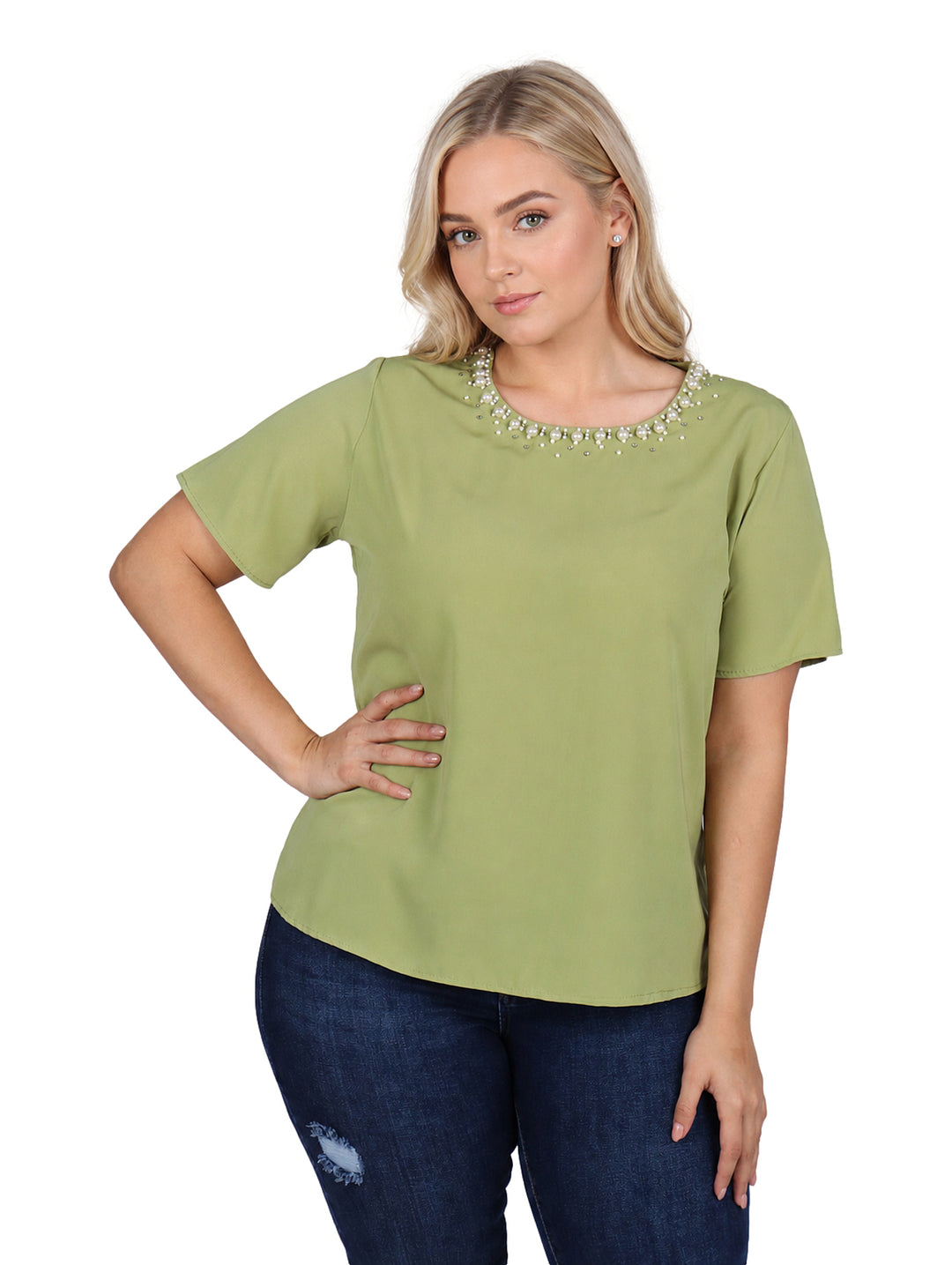 Mujer vistiendo blusa verde de manga corta con detalles de perlas en el cuello y jeans azules.