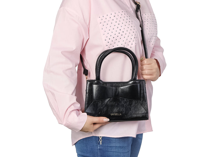 Bolso negro sintético con diseño acolchado y placa metálica de la marca UNIBELLA.