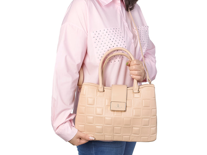 Bolso de mano color beige con diseño acolchado y placa metálica dorada.