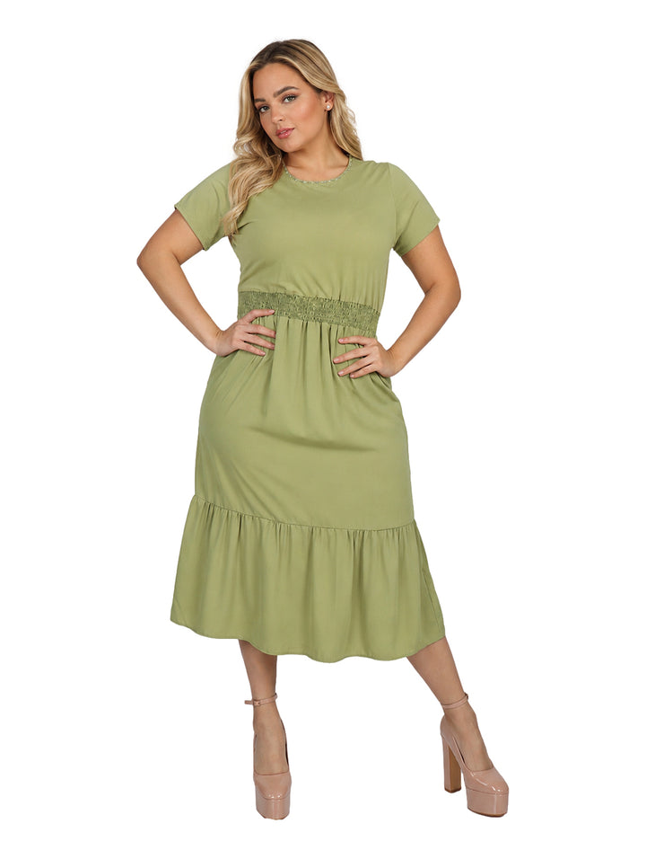 Mujer vistiendo un vestido color olivo de manga corta con cintura elástica y falda con volante.