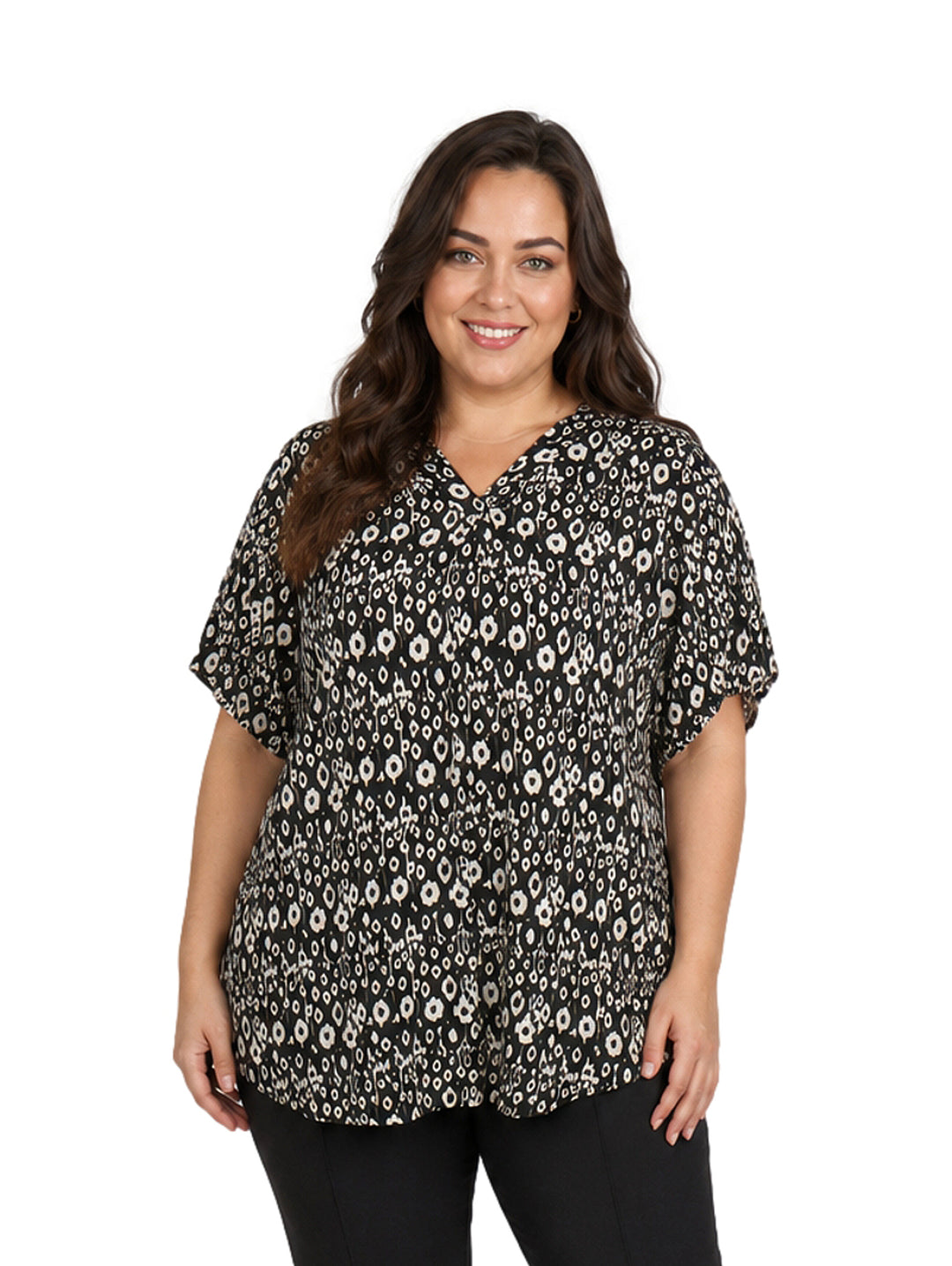 Mujer vistiendo blusa negra con estampado de flores blancas, cuello en V y manga corta.