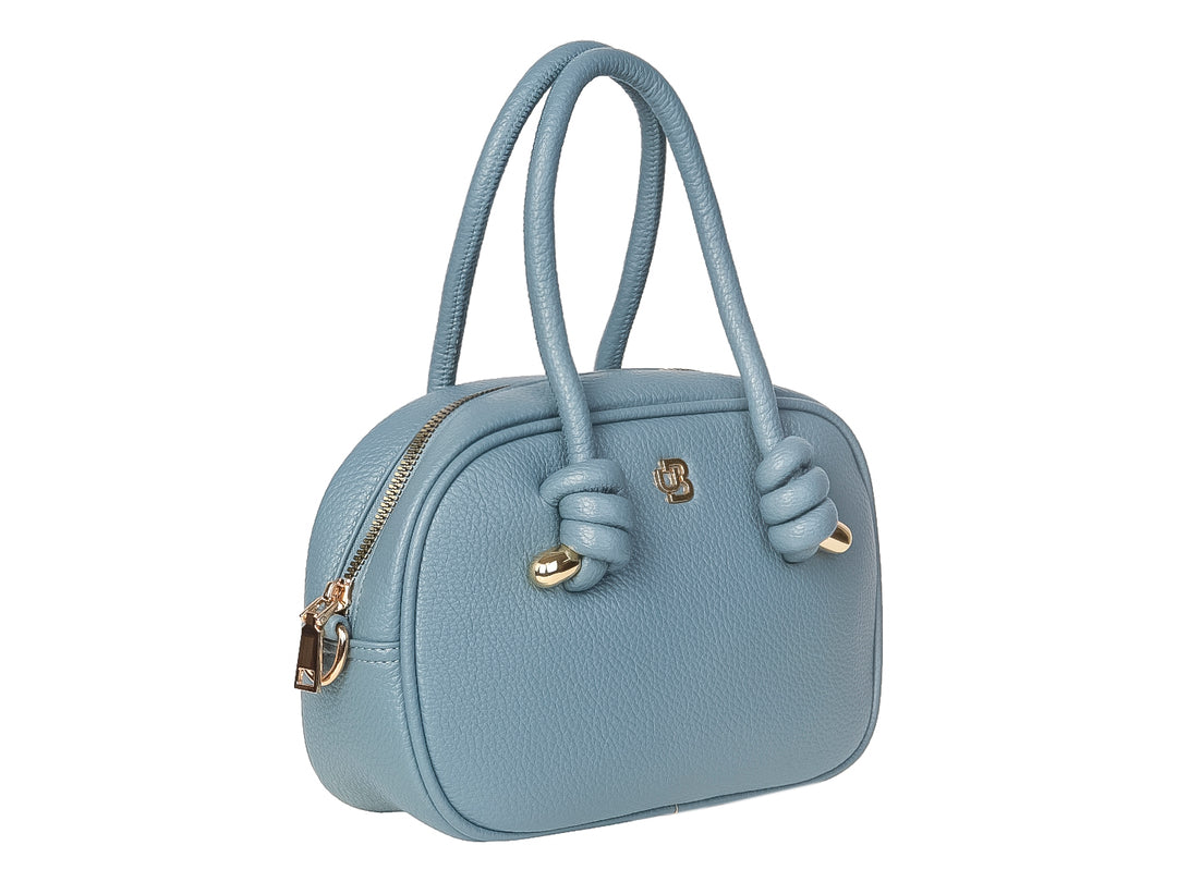 Bolso de mano color azul jeans con asas superiores y detalles dorados en forma de nudos.