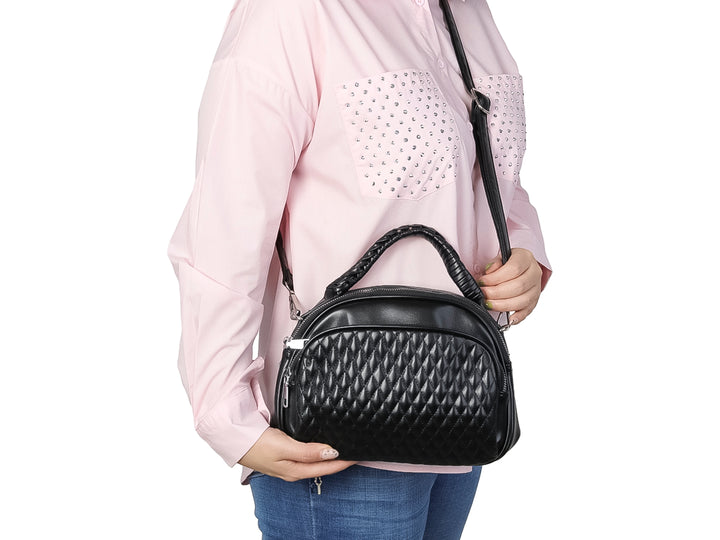 Bolso negro de material sintético con diseño acolchado en forma de diamante y asa superior trenzada.