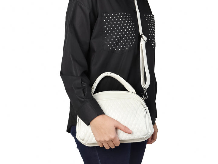 Bolso de mano color blanco con textura acolchada en forma de rombos y asa superior trenzada.