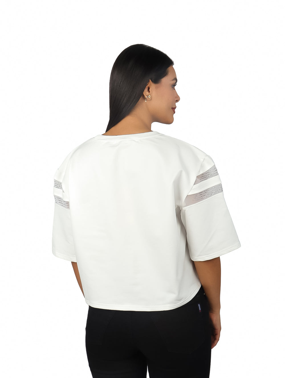 Mujer vistiendo un crop top blanco de manga corta con panel central y detalles laterales en color gris.