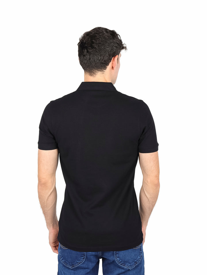 Hombre vistiendo una playera polo de color negro de manga corta con cuello y botones.