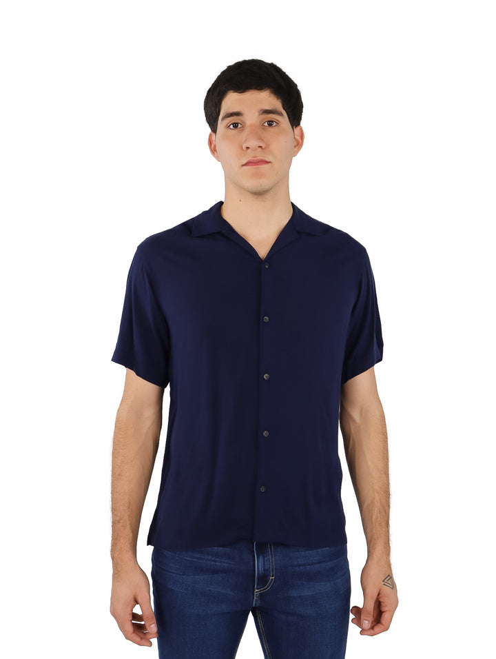 Hombre vistiendo una camisa de manga corta color azul marino estilo resort.
