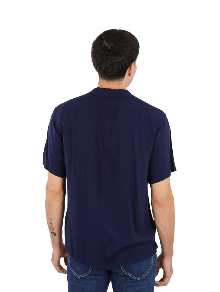 Hombre vistiendo una camisa de manga corta color azul marino estilo resort.