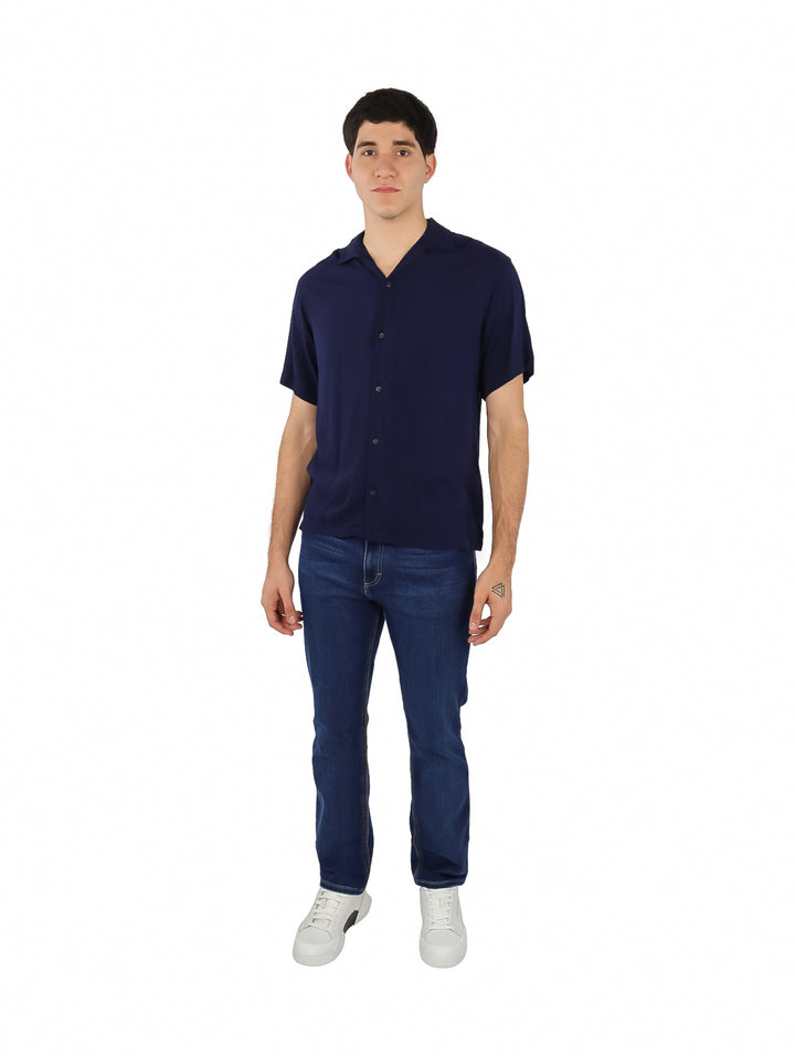 Hombre vistiendo una camisa de manga corta color azul marino estilo resort.