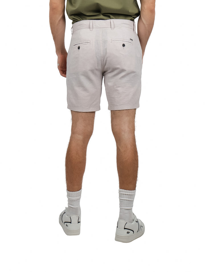 Hombre usando pantalones cortos de lino en color gris claro, estilo casual.