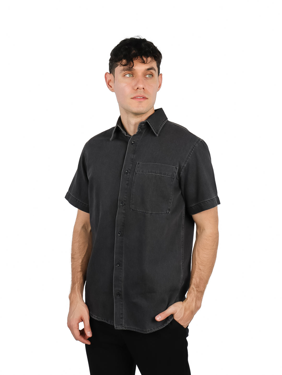 Hombre vistiendo una camisa de mezclilla color negro con manga corta y un bolsillo frontal.