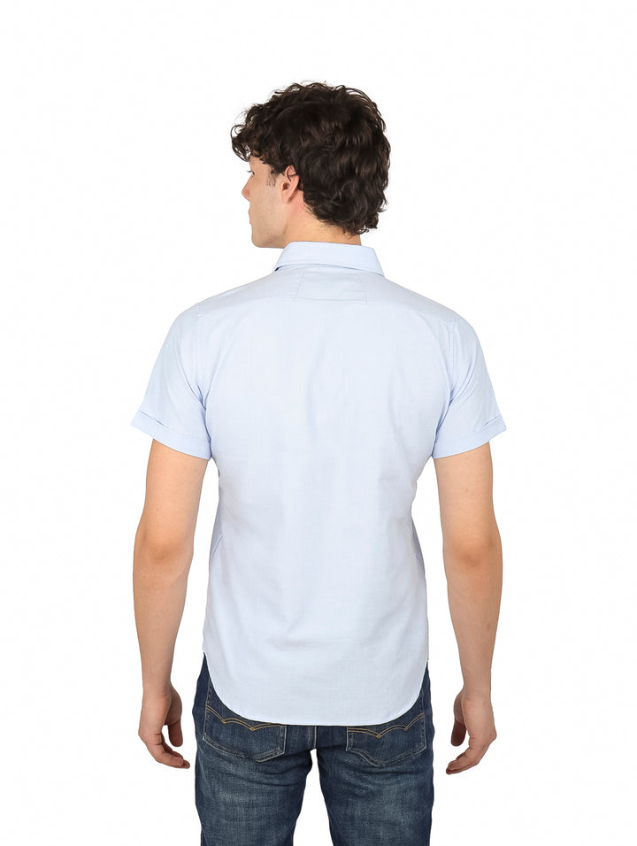 Hombre vistiendo una camisa casual de color azul claro con manga corta y botones frontales.