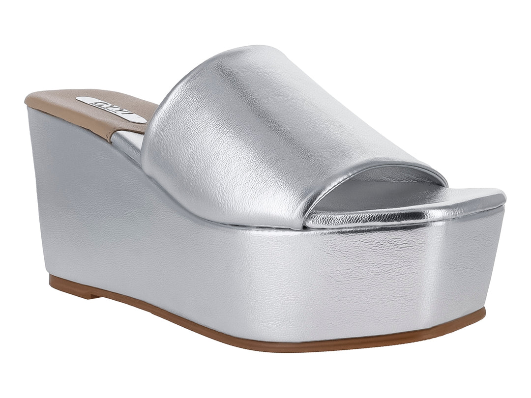 Sandalia de plataforma alta color plata metálico con diseño de banda ancha y suela beige.