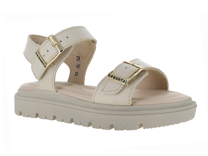 Sandalia beige con plataforma de suela dentada y hebillas doradas.