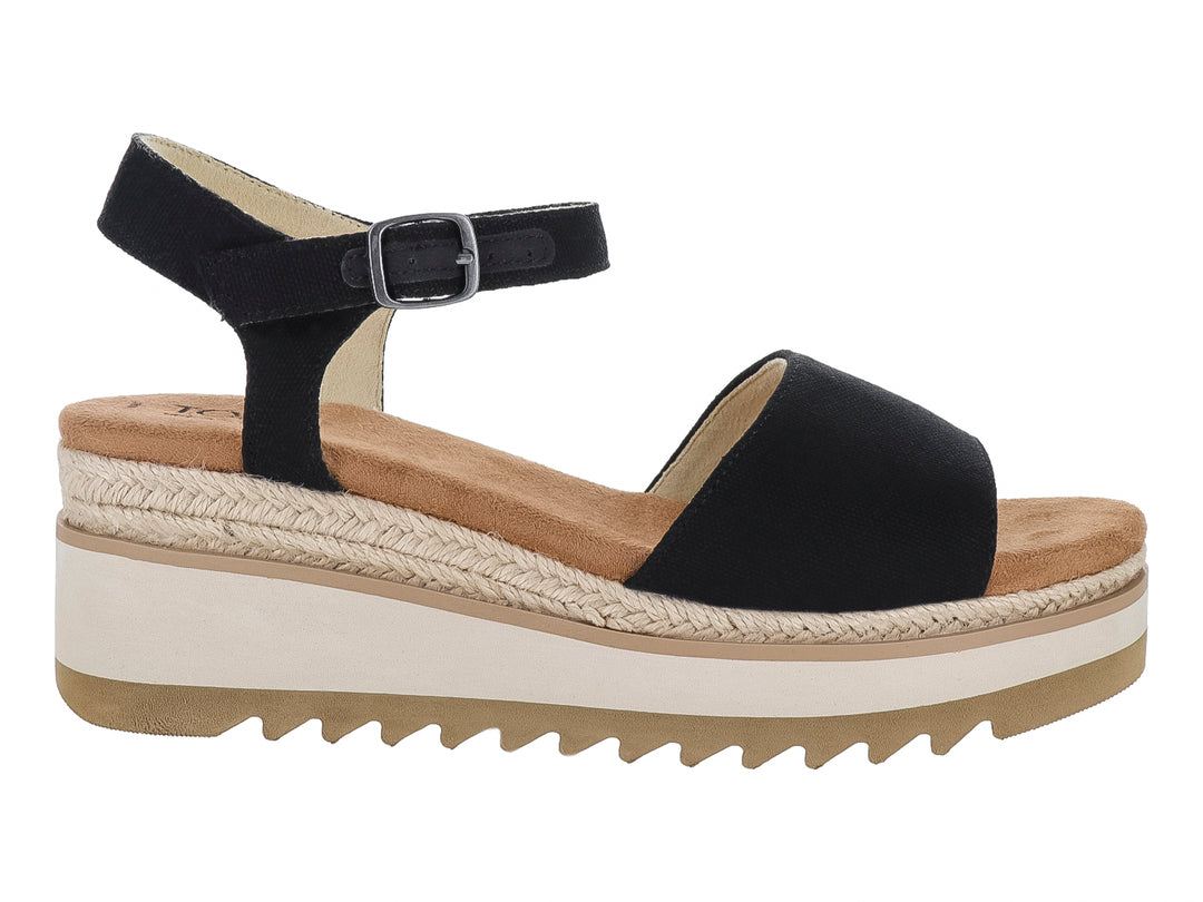 Sandalia de plataforma TOMS color negro con suela blanca y detalle de esparto en la cuña.