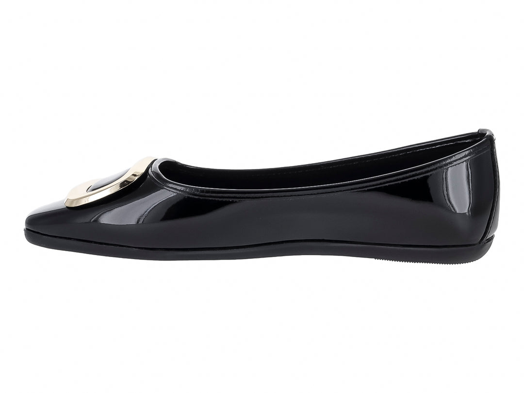 Zapato plano color negro brillante con hebilla decorativa dorada en la parte frontal.