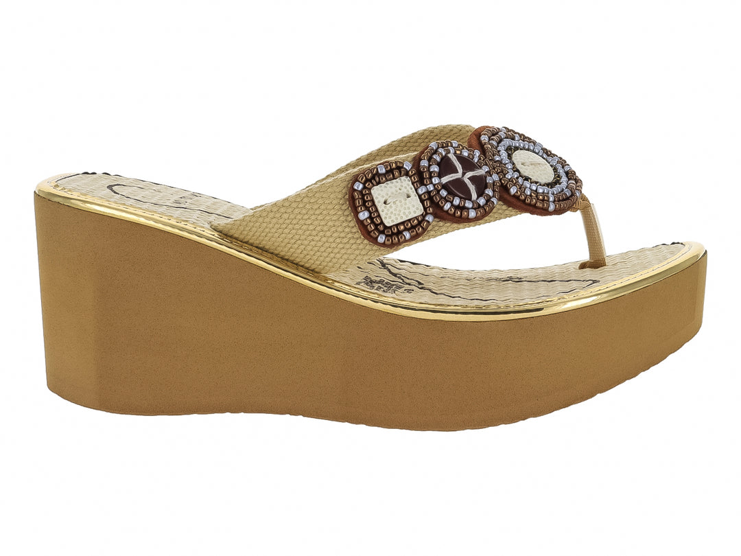 Sandalia de plataforma color beige con adornos circulares decorados con pedrería en la parte superior.
