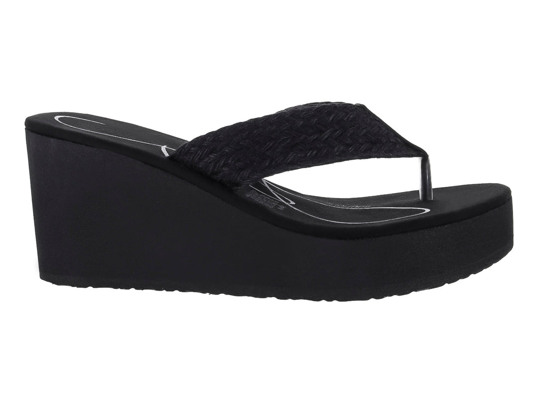 Sandalia de plataforma color negro con tira trenzada y suela de cuña.