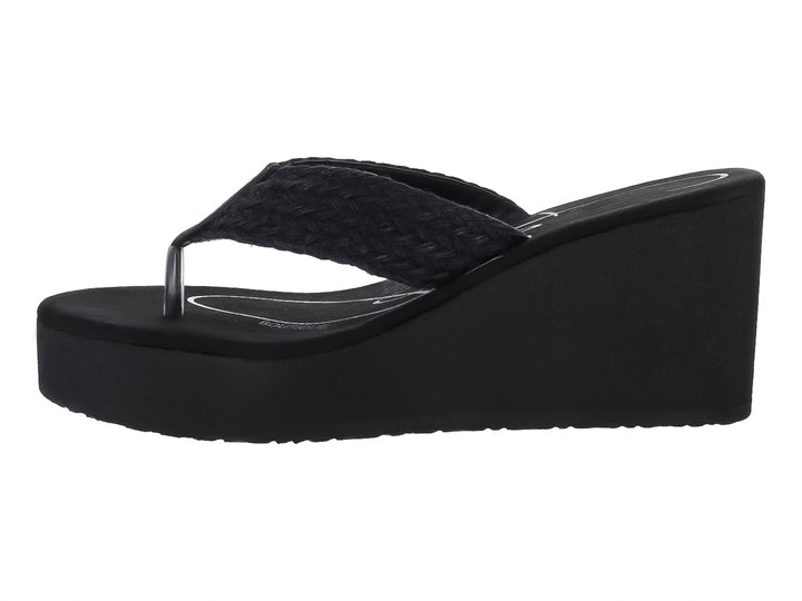Sandalia de plataforma color negro con tira trenzada y suela de cuña.