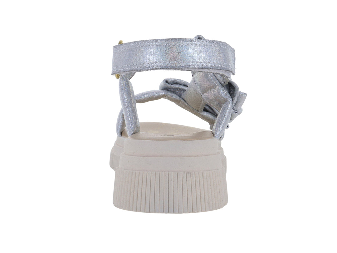 Sandalias plateadas para Niña con plataforma blanca y detalles de moños decorativos.