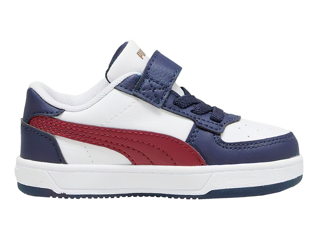Tenis PUMA infantiles en colores blanco y azul marino con franja roja y cierre de velcro.