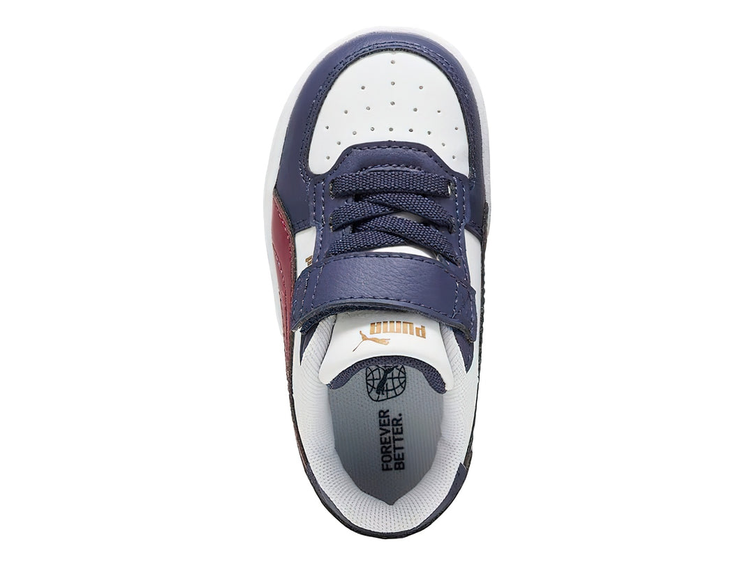 Tenis PUMA infantiles en colores blanco y azul marino con franja roja y cierre de velcro.