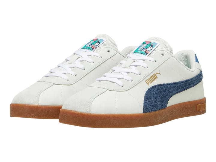 Tenis PUMA blancos con franja azul marino y suela de goma color café.